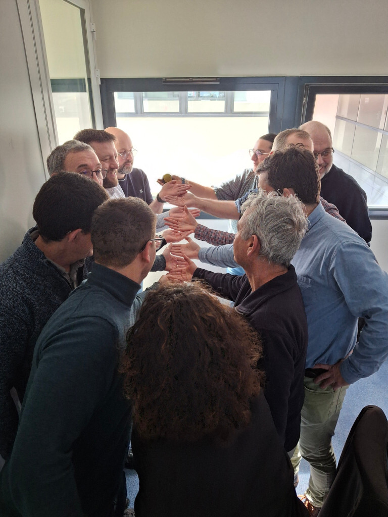 Équipe en cercle, mains jointes.
