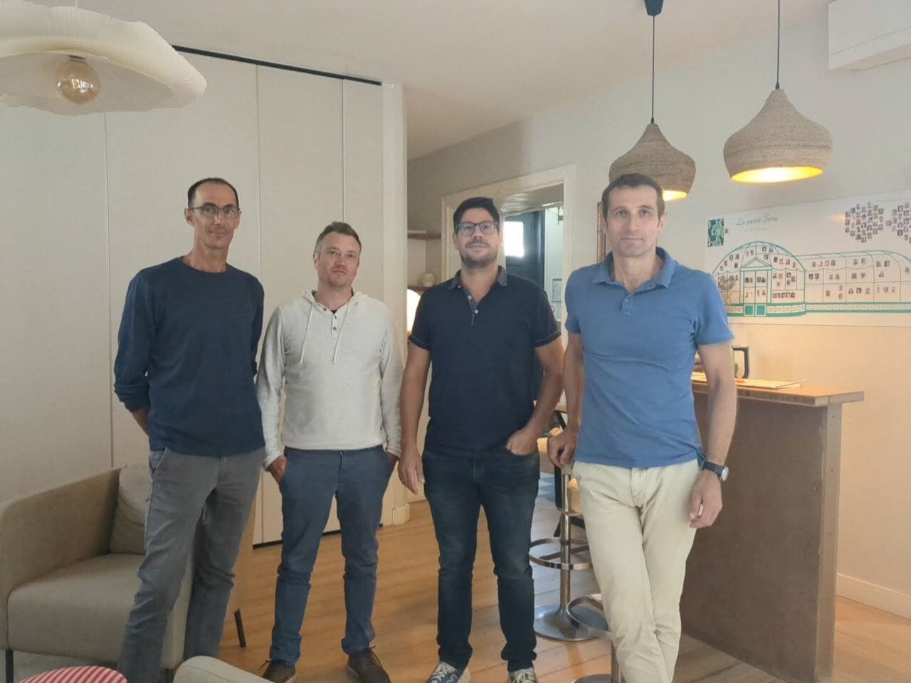 Quatre hommes posent ensemble.